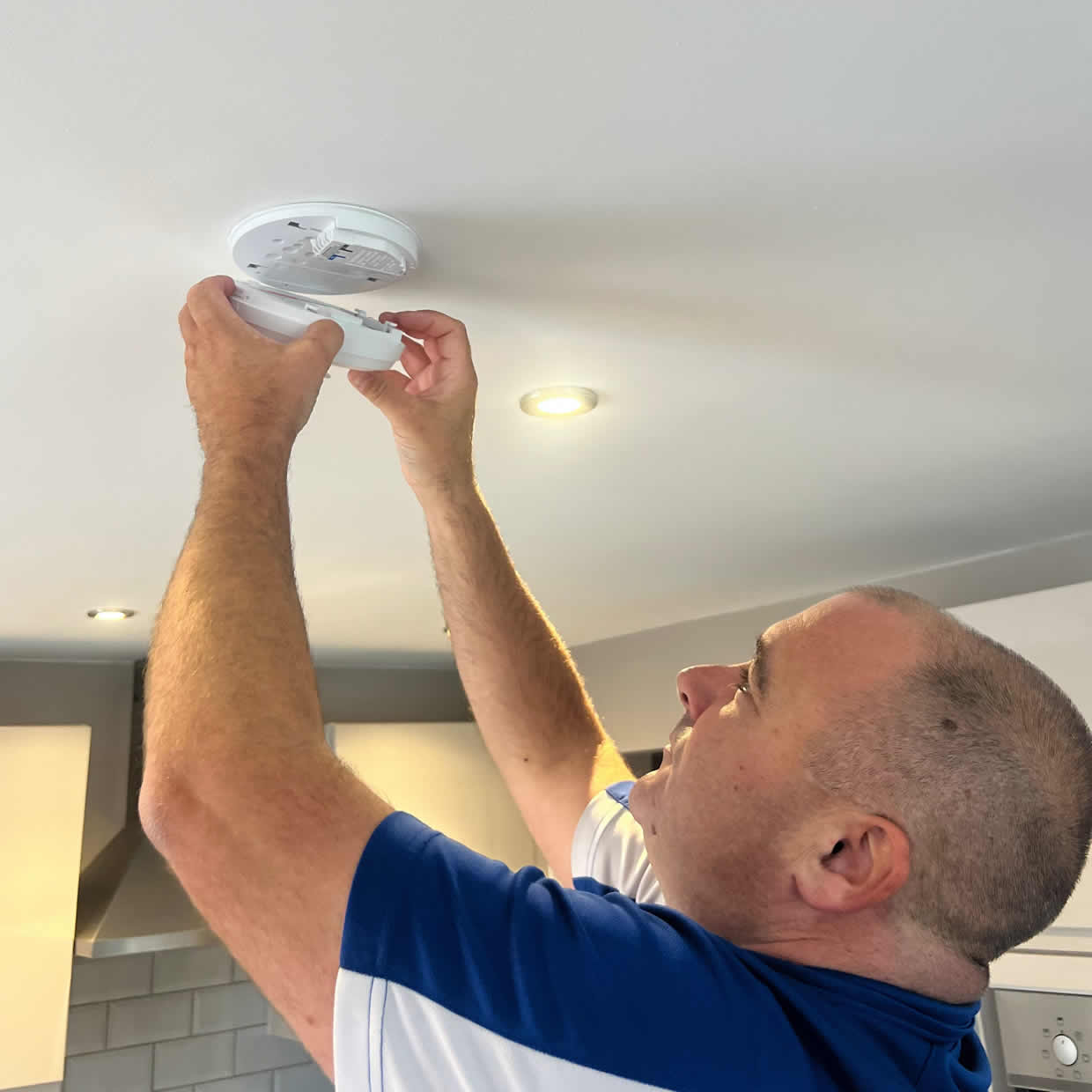 Smoke alarm being installed on a ceiling in Bicester